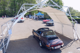 Purple car under protected tent structure at car event