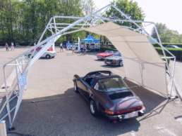 Purple car under protected tent structure at car event