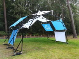 Pop up tent structure with blue and white panels for brand activation