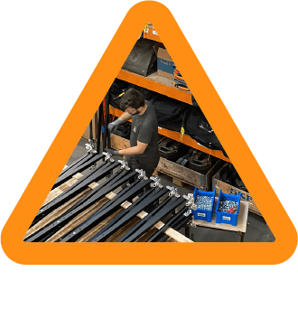Orange triangle with a picture of our workshop with white text underneath saying: "patience is a virtue"
